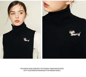 Detailansicht der Strass-Dackel-Brosche auf einem schwarzen Rollkragenpullover.