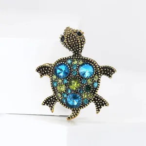 Detailed view of a vintage alloy turtle brooch adorned with sparkling blue and green crystals.