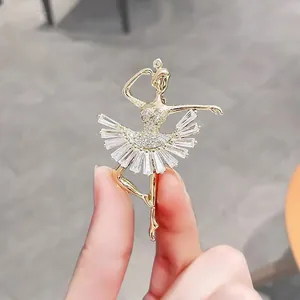 Detailed close-up view of a sparkling gold-tone ballerina brooch featuring a crystal tutu