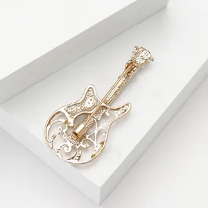 Detailed back view of a gold-tone alloy guitar brooch showing the pin closure mechanism.