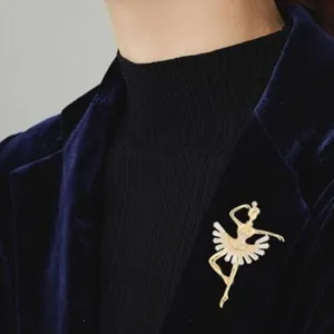 Elegant gold ballet girl brooch with sparkling crystals on a dark navy velvet blazer.
