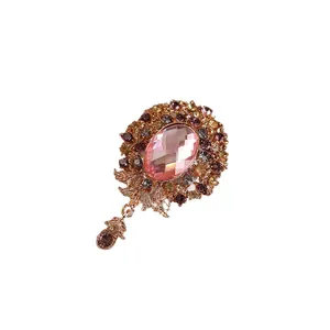 Elegant vintage flower brooch with pink faceted glass gemstone and colorful rhinestones