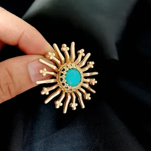 Detailed view of a retro matte gold Baroque brooch featuring a round turquoise center stone