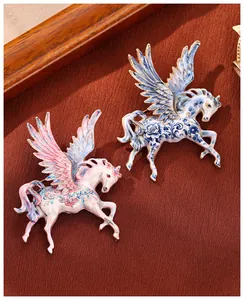 Macro view of blue and pink enamel Pegasus brooches with intricate floral patterns