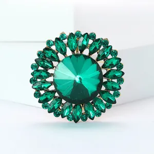 Vue détaillée d'une broche fleur vintage en cristal vert et alliage d'or