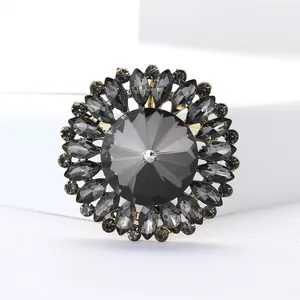 Détail d'une broche fleur vintage en cristal gris pour tailleur femme