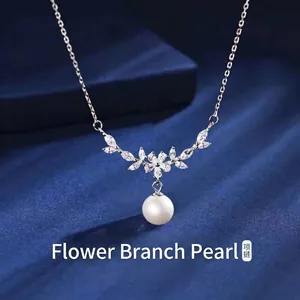 Gedetailleerde close-up van elegante parelketting met bloemtak op blauwe zijden stof