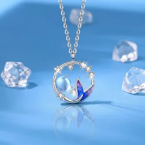 Dreamy silver mermaid tail necklace featuring a glowing blue moon and sparkling star accents