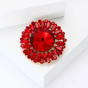 Broche fleur élégante avec cristaux rouges et monture en alliage doré