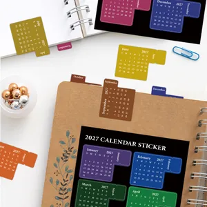 Dettaglio delle schede indice del calendario mensile 2027 su una pagina di agenda ad anelli.