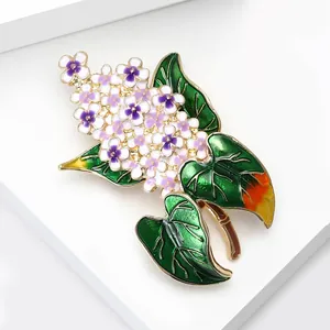 Detailansicht der antiken Emaille-Flieder-Brosche mit lila Blüten und grünen Blättern.