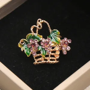 Detailed macro view of an elegant gold basket brooch featuring purple rhinestones.