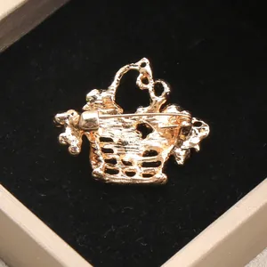 Macro detail view showing the secure back pin mechanism of the golden alloy basket brooch