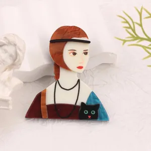 Close-up of artistic acrylic brooch featuring a portrait of a girl with a black cat.
