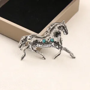 Detailed view of a vintage horse brooch with antique silver finish and blue stones