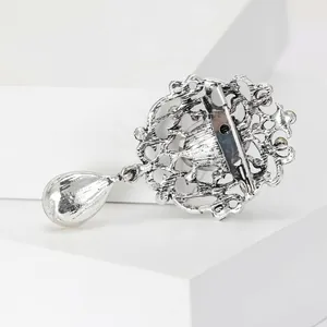 Professional back view of a vintage silver filigree brooch with safety pin clasp