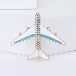 Detailansicht einer eleganten Flugzeugbrosche mit funkelnden Strasssteinen und Emaille