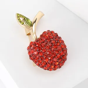 Macro view of a sparkling red rhinestone apple brooch for elegant fashion outfits.