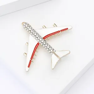 Detailaufnahme einer kreativen Flugzeug-Brosche mit Strass und weißer Emaille.