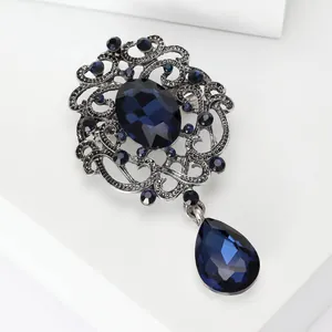 Detail of a vintage-style antique silver brooch featuring deep blue faceted crystals