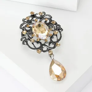 Detailed view of vintage crystal brooch with amber rhinestones and filigree design