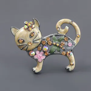 Dettaglio macro di una spilla a forma di gatto vintage con strass colorati e fiori