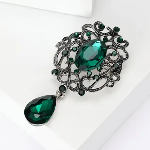 Detailed view of vintage green crystal brooch with antique silver alloy and rhinestones