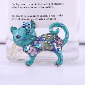 Primo piano di una spilla a forma di gatto vintage in smalto blu con strass colorati