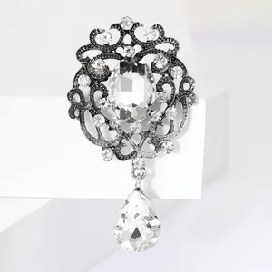 Macro detail of high-quality teardrop crystal pendant dangling from a silver brooch