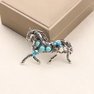 Vintage silver-toned alloy running horse brooch with vibrant faux turquoise inlays