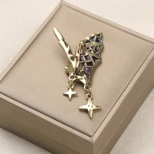 Vintage gold gothic bat wing brooch with red enamel inlay and celestial dangling star charms