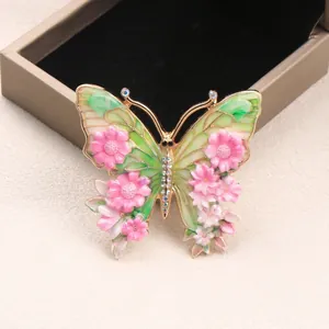 Vintage Schmetterlingsbrosche mit Blumenmustern und bunten Strasssteinen auf Gold.