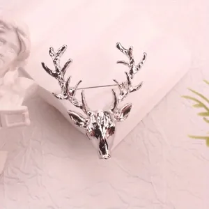 Macro detail view of a polished silver alloy deer head brooch for festive outfits