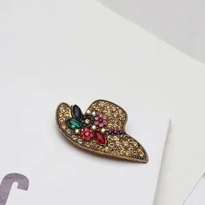 Vue détaillée d'une élégante broche chapeau de soleil avec accents floraux en strass
