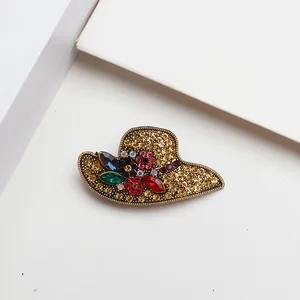 Vue détaillée d'une élégante broche en forme de chapeau de soleil ornée de strass colorés