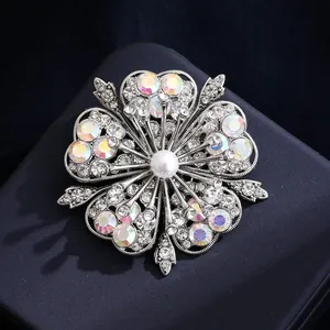 Eleganter silberner Blumen-Brosche mit funkelnden Kristallen und Perle auf blauer Box