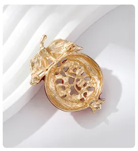 Back view detail of a gold-plated pomegranate brooch pin with secure clasp