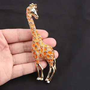 Vista dettagliata della spilla a giraffa in smalto arancione con strass marroni.