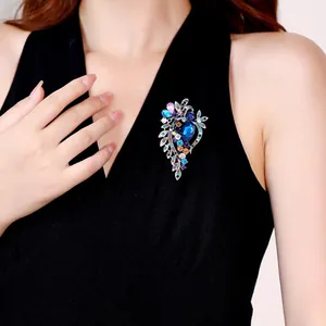 Detailopname van een vintage kristallen broche met gekleurde strass op zwarte jurk