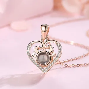 Detailopname van een roségouden hartprojectie ketting met rendiergewei-accent en steentjes.