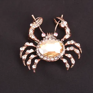 Close-up of a vintage-style crab brooch with amber crystal and sparkling rhinestones