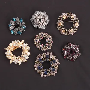 A collection of seven elegant wreath-shaped floral brooches featuring colorful crystal rhinestones