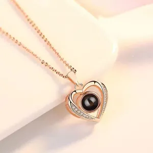 Detailopname van een roségouden hartketting met centrale projectiesteen en kristallen