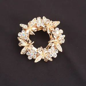 Detailed view of elegant golden wreath brooch featuring sparkling crystals and flowers