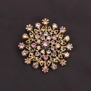 Macro view of vintage gold flower wreath brooch with pink rhinestones