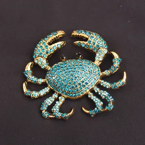 Close-up detail of a golden crab brooch encrusted with shimmering blue rhinestones