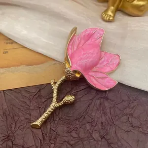 Elegant pink enamel magnolia flower brooch pin with gold-tone stem for retro accessories.