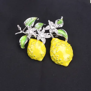 Close-up view of an elegant lemon fruit brooch featuring yellow enamel and sparkling crystals