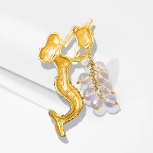 Vue détaillée de l'arrière d'une luxueuse broche sirène dorée avec perles irisées