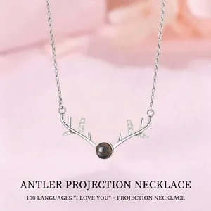 Silver-toned antler pendant projection necklace featuring 'I love you' in 100 languages